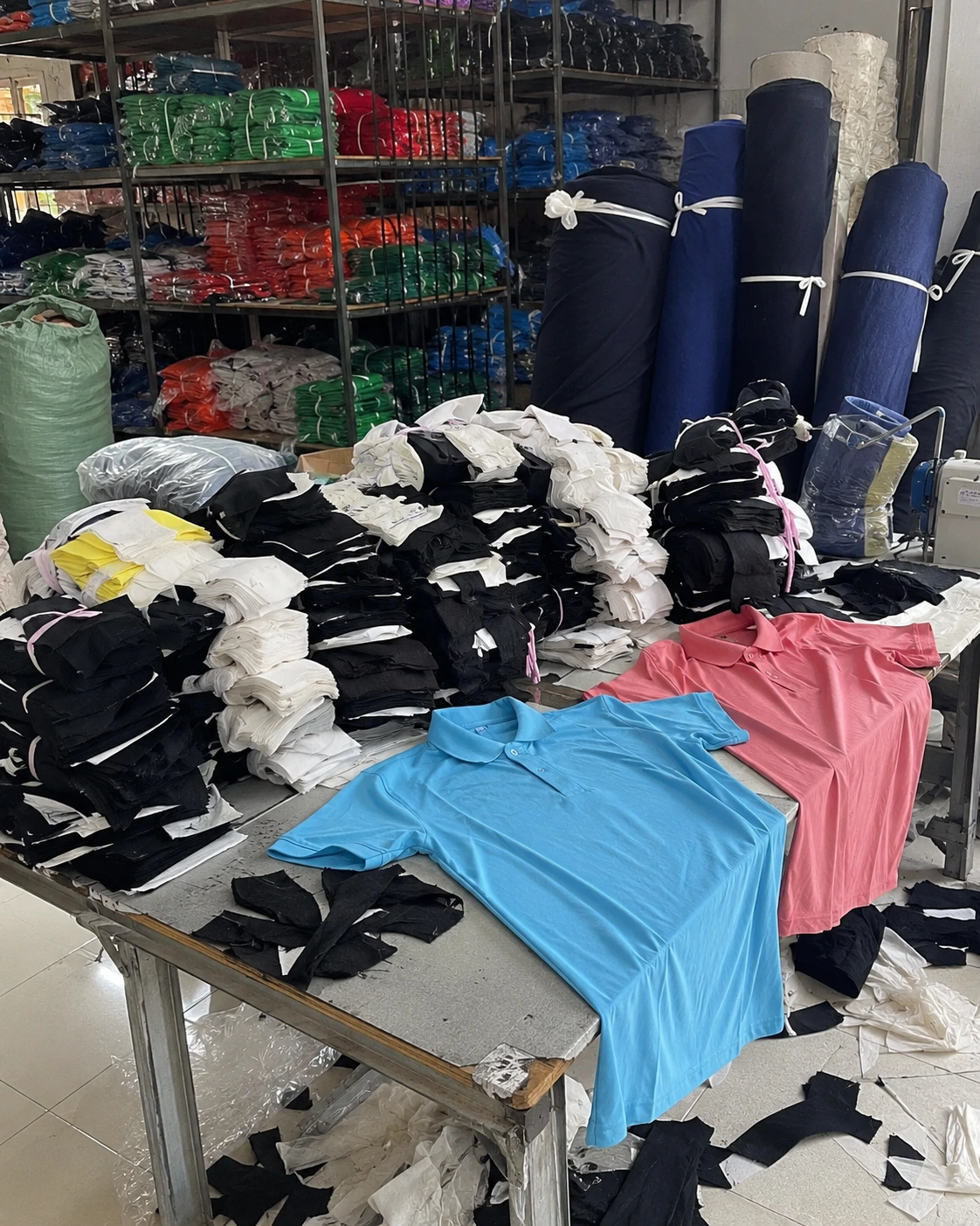 Bàn cắt vải áo polo đồng phục màu đen trắng và phụ kiện cổ tay áo tại xưởng